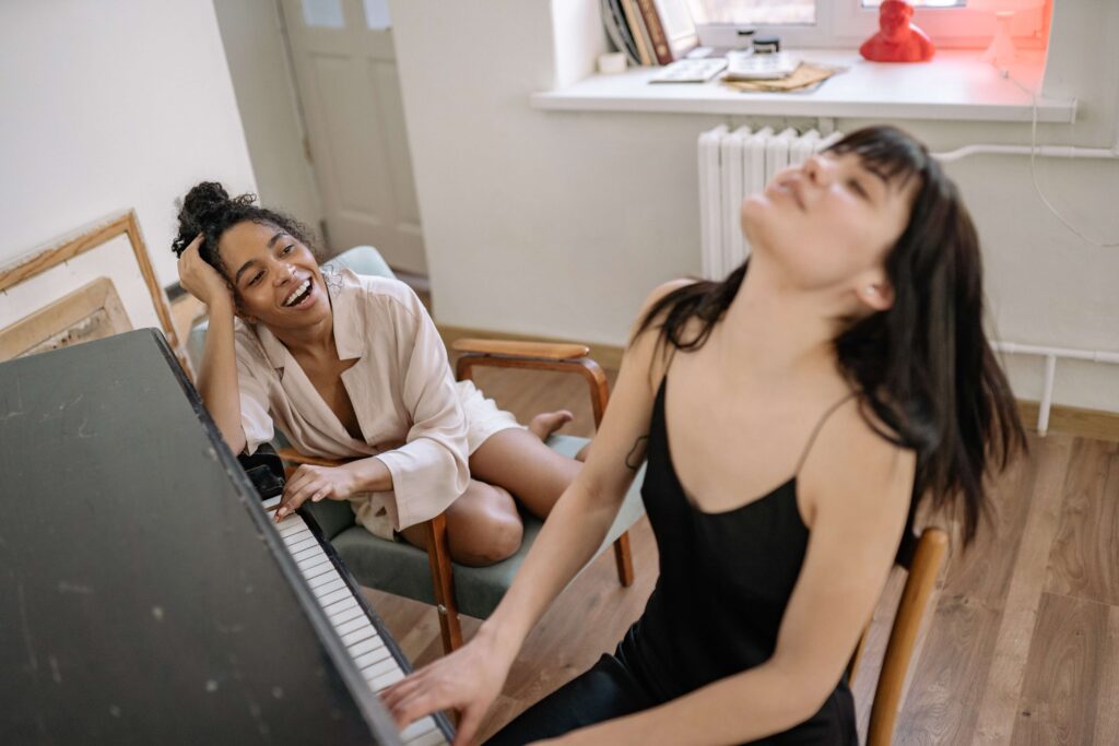 A woman plays the piano passionately as her partner looks on representing a couple who has found ways to reconnect through Couples Therapy in Burbank, CA. 