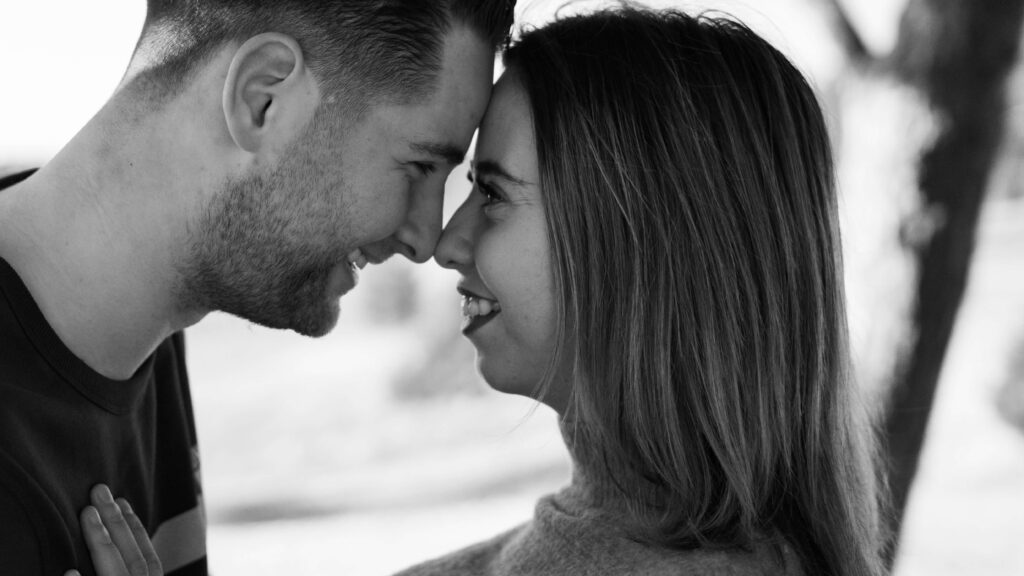 A couple stands with their foreheads touching while smiling at each other representing the importance of intimacy in a relationship. Learn more in Couples Counseling in Burbank, CA.