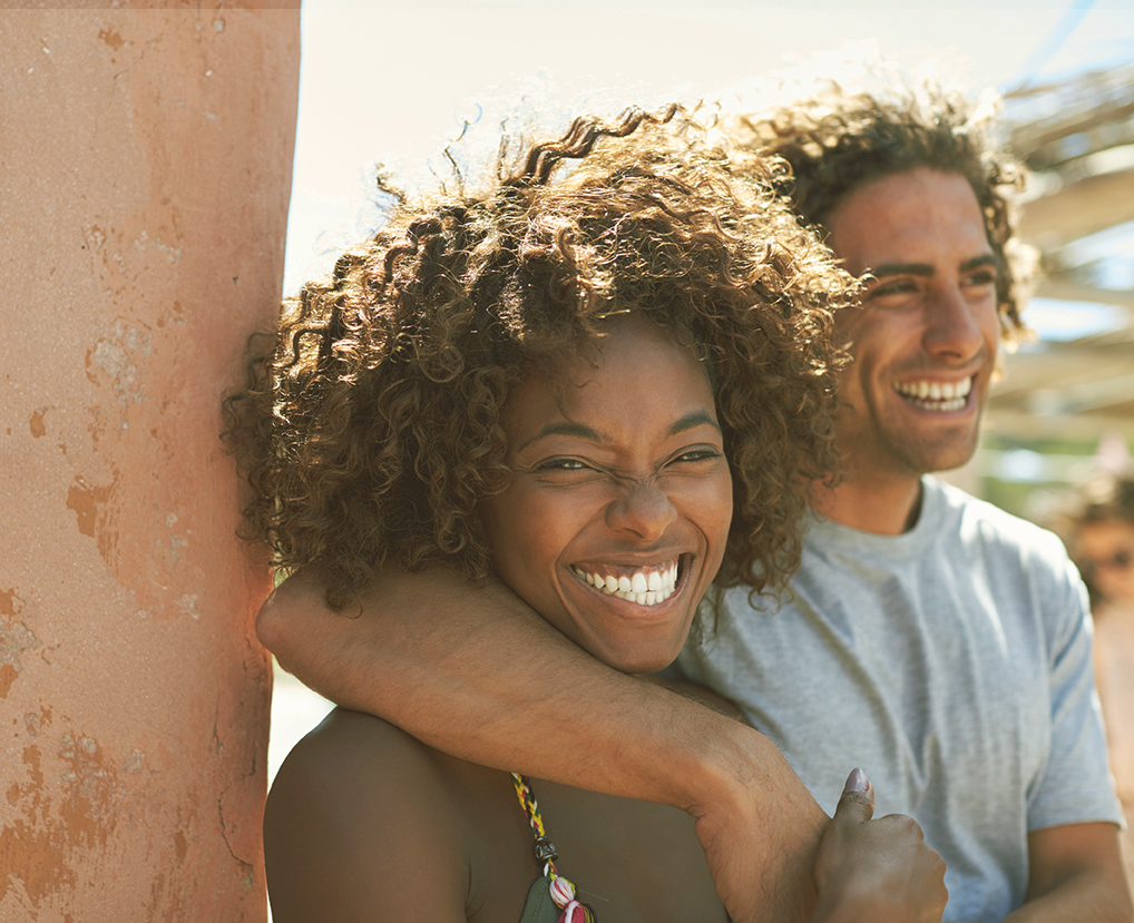 A couple embraces while smiling happily representing a couple that has reconnected with the help of Couples Therapy in Burbank, CA.
